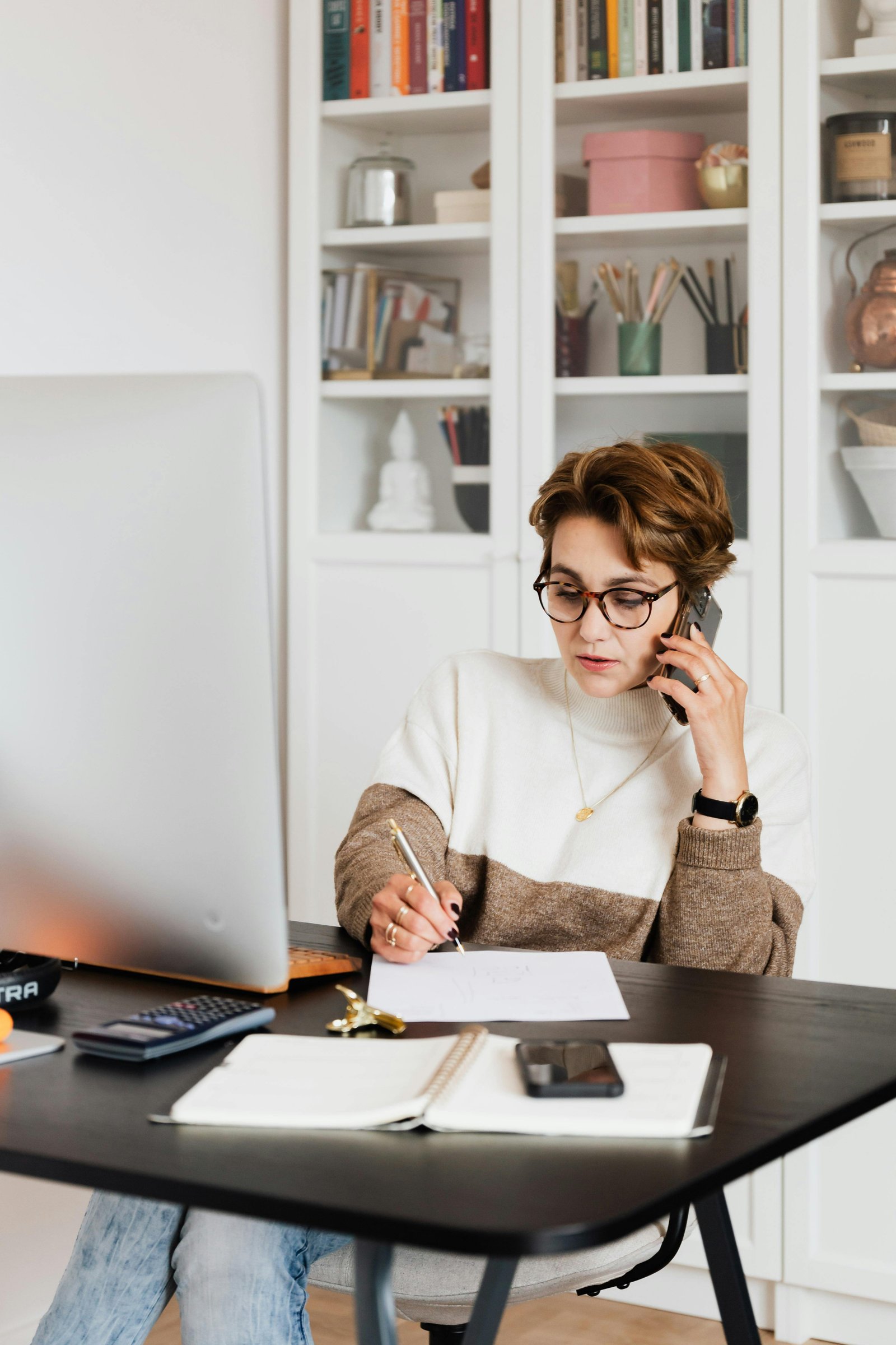 Người đang ghi chú tiếng Anh trên giấy và máy tính