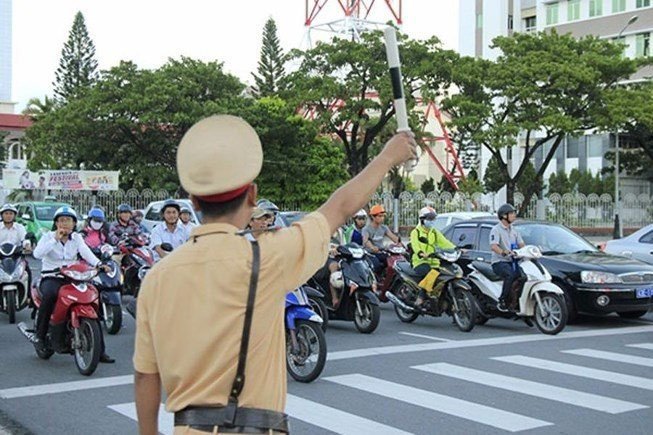 Người cảnh sát giao thông đang điều khiển luồng giao thông trên đường phố