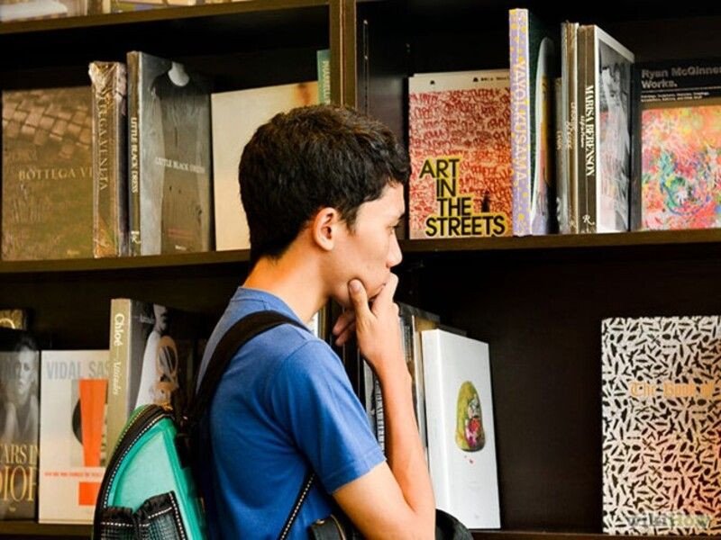 Tay chọn sách từ giá, thể hiện bước lựa chọn sách phù hợp.