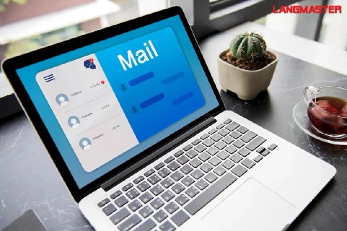 Bàn làm việc với laptop mở email, minh họa mẫu thư phản hồi tài liệu
