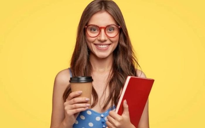 Bàn làm việc với sách vở, máy tính xách tay và ly cà phê, tượng trưng cho quá trình chuẩn bị kế hoạch du học tiếng Anh tỉ mỉ.