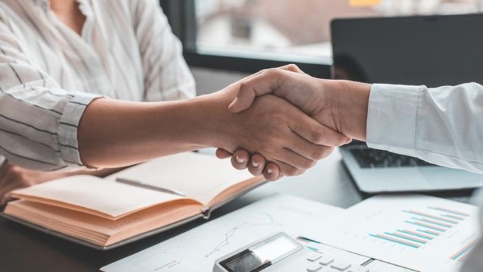 Các thành viên trong nhóm làm việc đang vỗ tay cho một thành viên khác, biểu thị sự cảm ơn và công nhận
