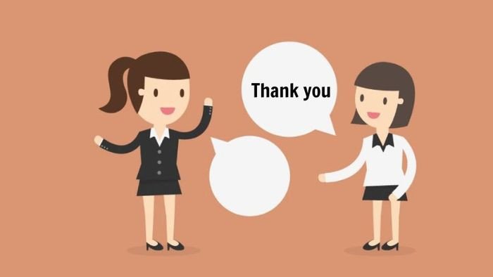 Hai người mỉm cười, một người tặng quà và người kia nhận quà với lời cảm ơn