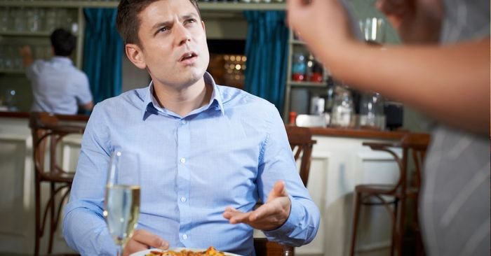 Khách hàng đang phàn nàn với quản lý về dịch vụ tại nhà hàng, minh họa cách khiếu nại bằng tiếng Anh.