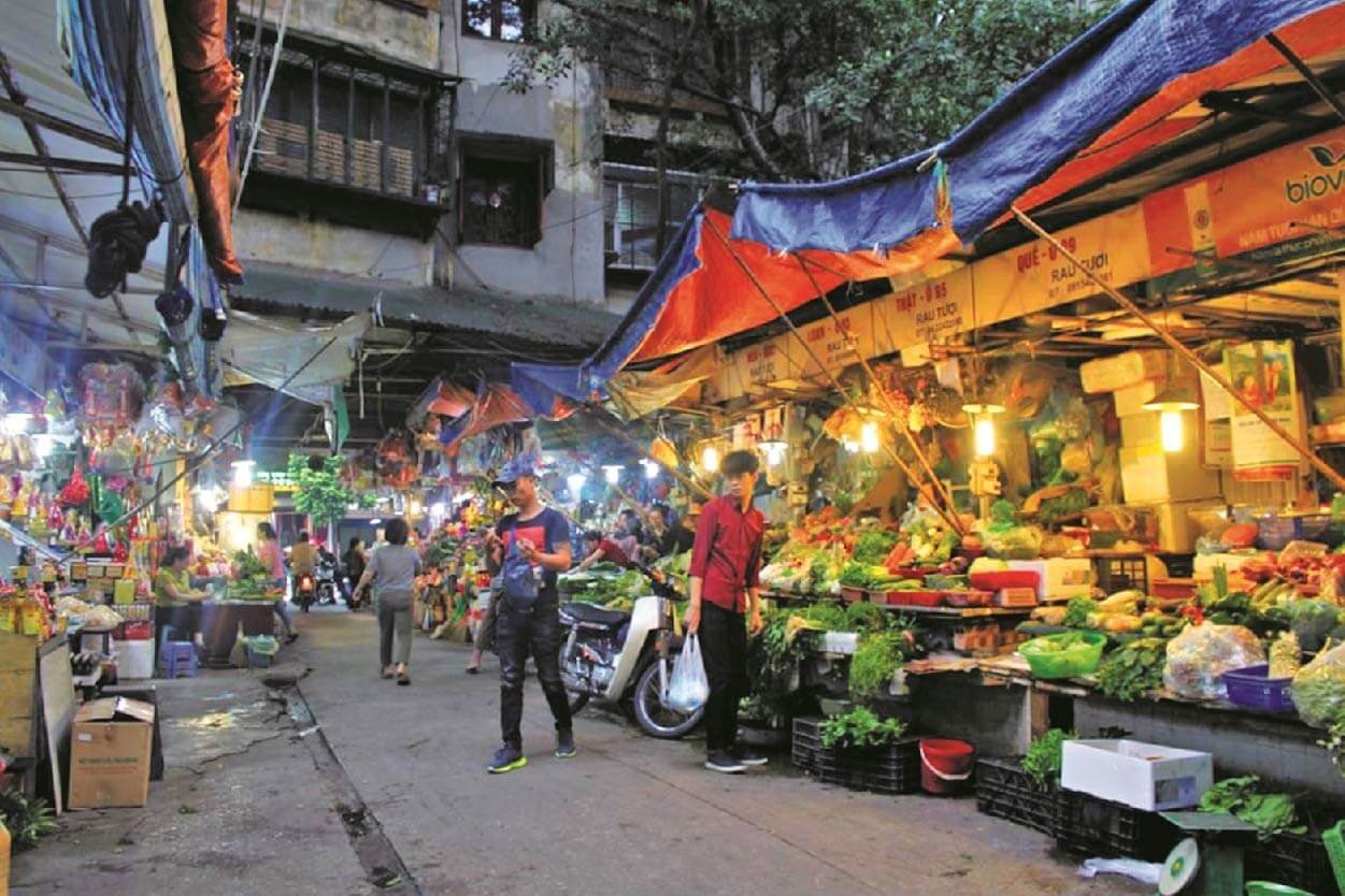 Khung cảnh sôi động của một khu chợ đường phố với nhiều gian hàng và người mua sắm, minh họa chủ đề Street Market