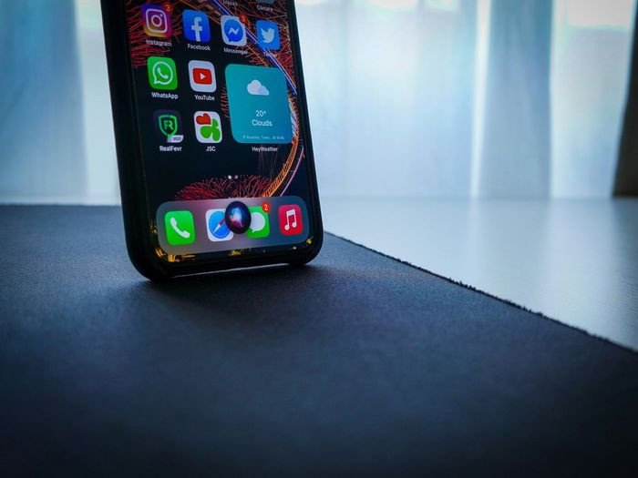 Màn hình iPhone hiển thị giao diện Siri với các câu lệnh tiếng Anh thực hành