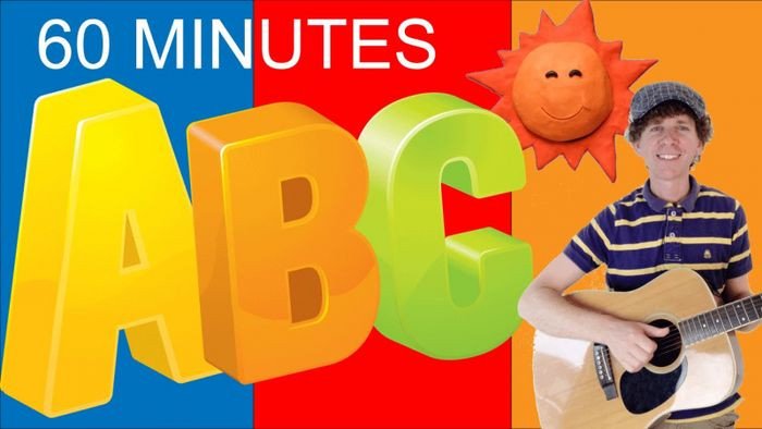 Một cậu bé mỉm cười đeo tai nghe đang xem video từ kênh Dream English Kids trên máy tính bảng