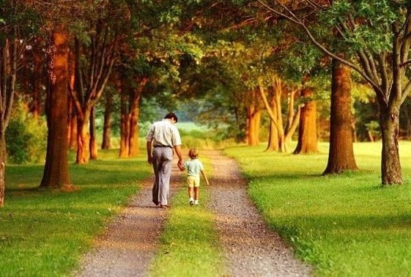 Một người đàn ông đang dạy con trai cách bơi lội trong bể bơi.