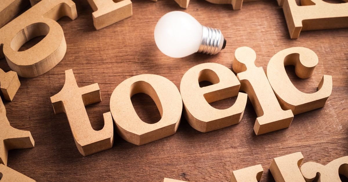 Một người phụ nữ nói chuyện vào micro với logo TOEIC, biểu thị bài thi nói