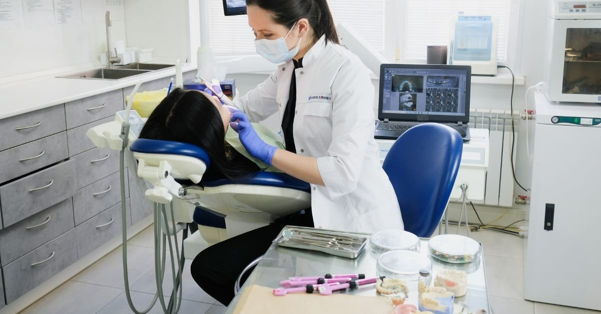 Một nha sĩ đang giao tiếp và giải thích tình trạng răng miệng cho bệnh nhân tại phòng khám
