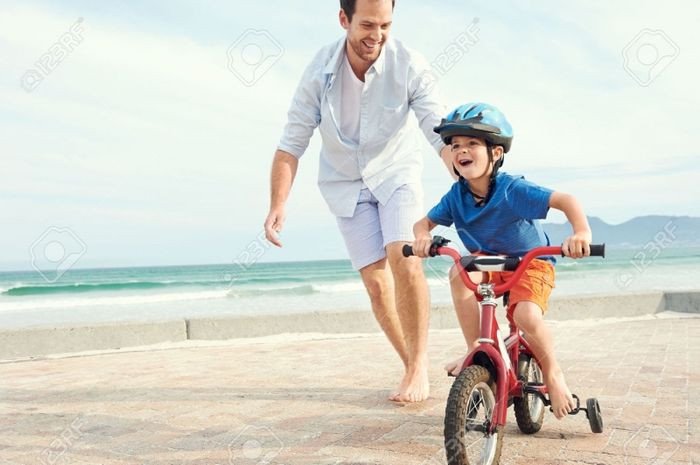 Người bố trẻ đang cười hạnh phúc khi chơi cùng con gái.