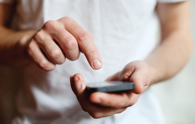 Người phụ nữ đang nghe điện thoại với vẻ mặt khó chịu, minh họa sự phiền toái từ những cuộc gọi lặp đi lặp lại.
