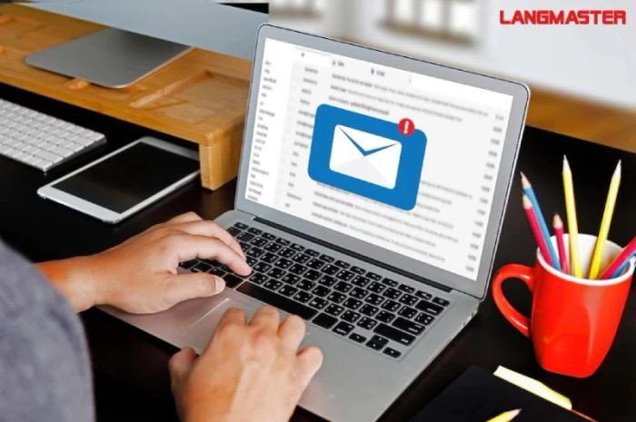 Người phụ nữ viết email trên máy tính, minh họa cấu trúc email tiếng Anh chuẩn