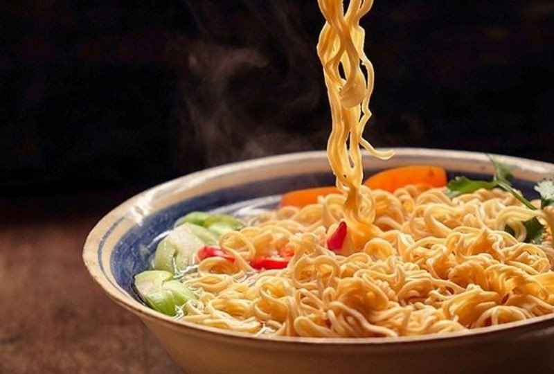 Bàn tay đang khuấy mì tôm nóng hổi