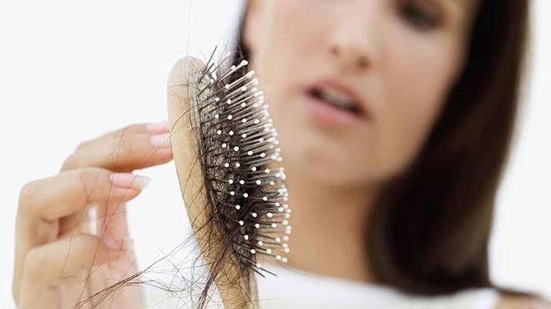 Bàn tay gom những sợi tóc rụng, liên tưởng đến con số may mắn
