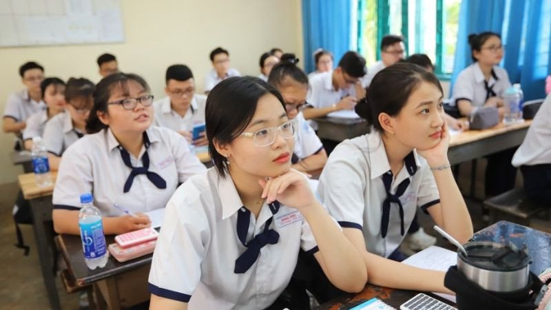 Cận cảnh tay một học sinh đang ghi chú cẩn thận vào cuốn sách