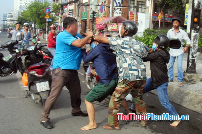 Đám đông hỗn loạn đang xô xát, tượng trưng cho mơ thấy đánh nhau tập thể