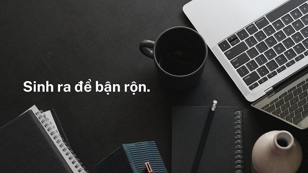 Hình ảnh một học sinh đang làm bài tập với một cuốn sách mở và laptop trên bàn, với khung cảnh cửa sổ nhìn ra thiên nhiên