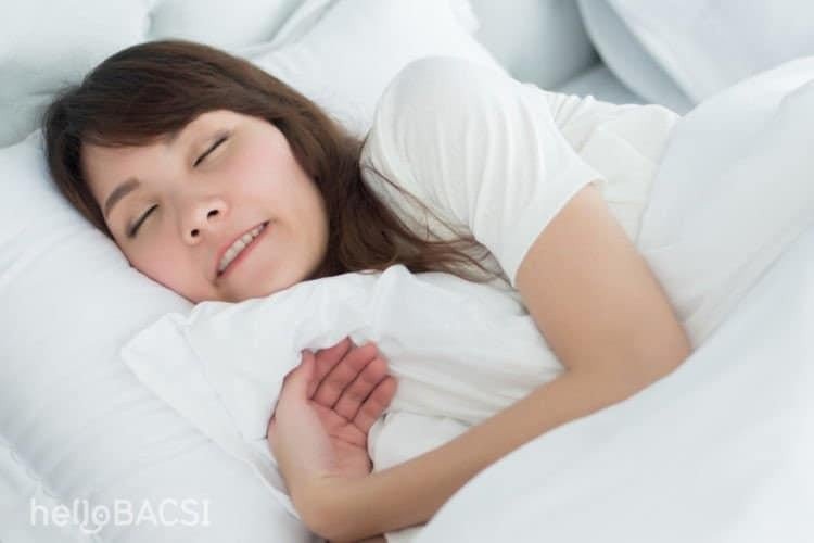 Hình ảnh một người đang nghiến răng trong giấc ngủ, nguyên nhân dẫn đến nằm mơ thấy rụng hết răng