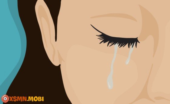 Hình ảnh một người đang ngồi một mình trong phòng tối, gục mặt khóc lóc trong đau khổ, đại diện cho những giấc mơ thấy khóc