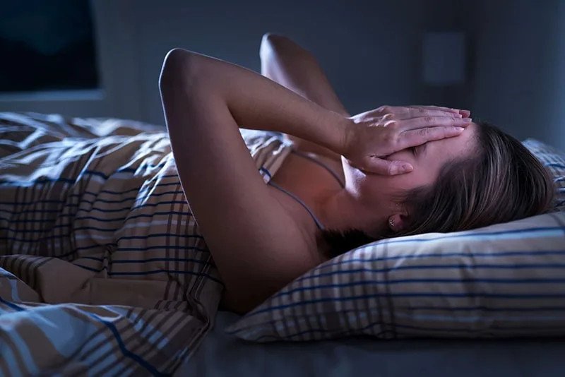 Hình ảnh một người đang ngủ và một bóng ma mờ ảo, minh họa cho câu hỏi tại sao không mơ thấy người thân đã mất.