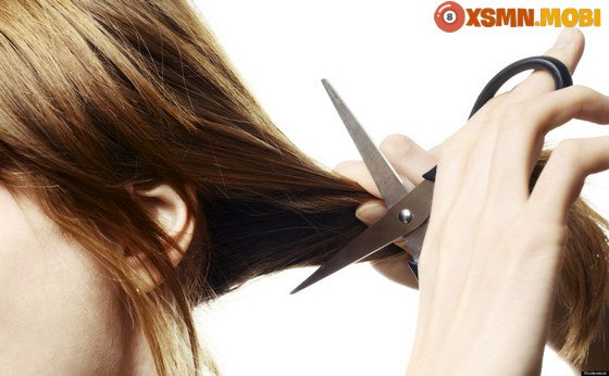 Hình ảnh một người phụ nữ đang có vẻ khó chịu với tóc trong miệng, thể hiện cảm giác bị cản trở