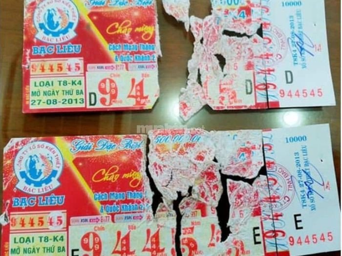 Hình ảnh vé số trúng độc đắc bị rách, tượng trưng cho những khó khăn và mất mát trong cuộc sống.