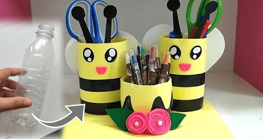 Học sinh vui vẻ sử dụng đồ dùng học tập tái chế trong lớp học, thể hiện lợi ích môi trường và giáo dục