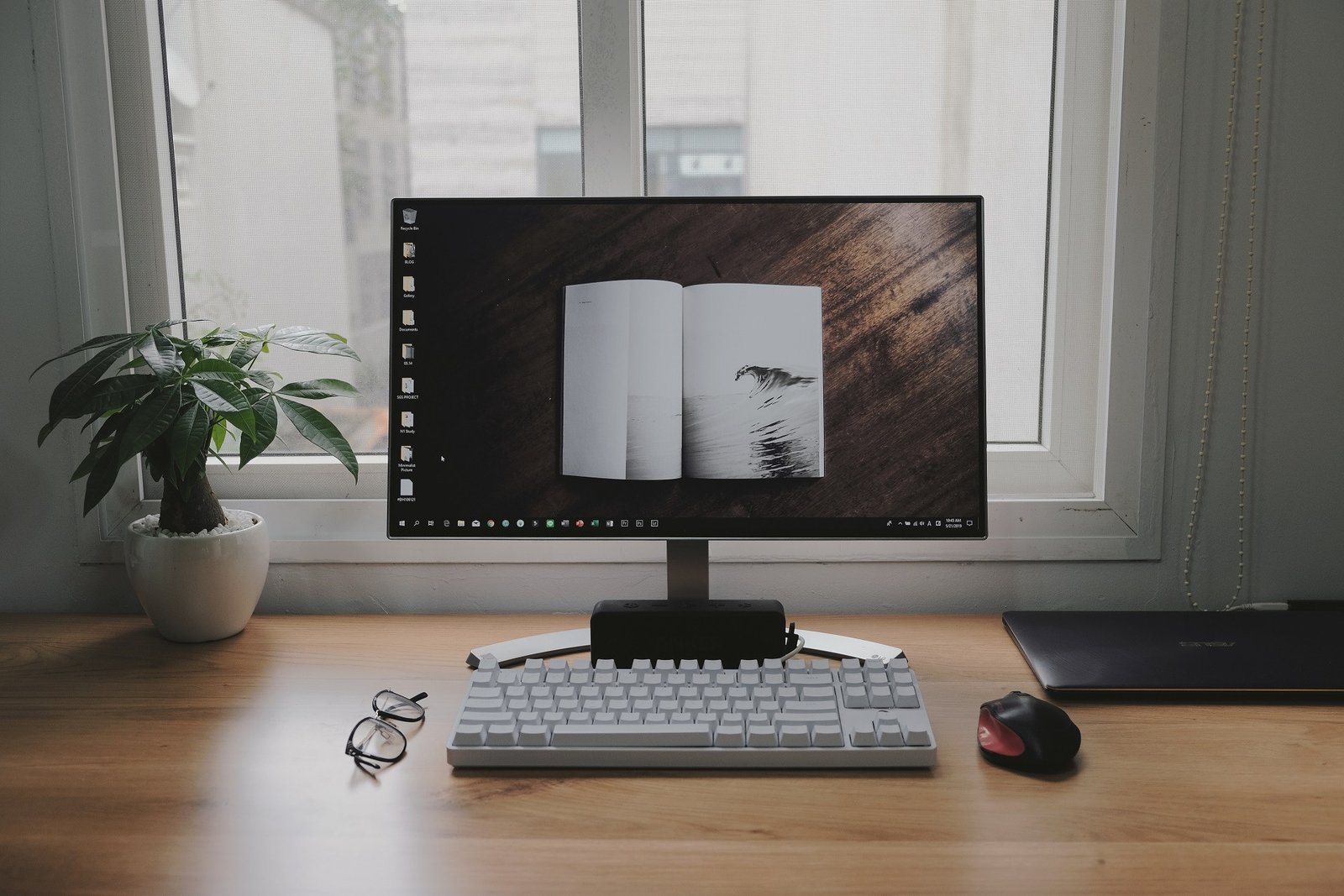 Mặt bàn làm việc tối giản với laptop, màn hình và cây xanh