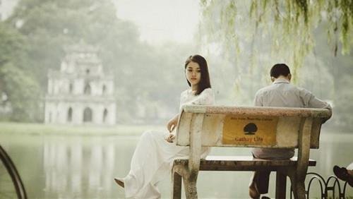 Một cặp đôi quay lưng lại nhau trong khung cảnh buồn bã, tượng trưng cho giấc mơ chia tay người yêu đầy cảm xúc.