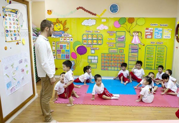 Một góc tường được trang trí thành không gian học tập mầm non, với tranh vẽ tường sinh động và bàn học nhỏ