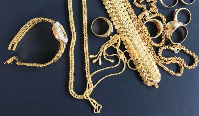 Một người đàn ông đang trao một món đồ trang sức vàng cho người khác, tượng trưng cho sự cho đi, nhận lại và những mối quan hệ có giá trị.