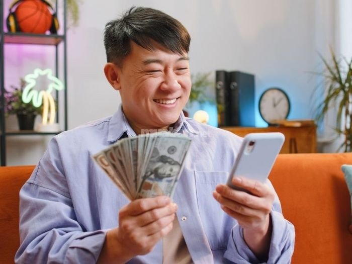 Một người đang buồn bã với vé số trúng giải nhỏ, báo hiệu những thử thách tài chính sắp tới.