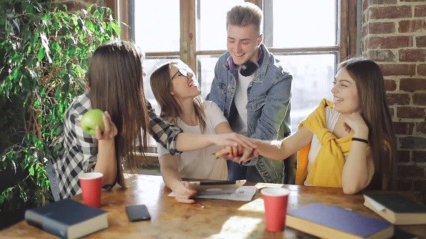 Một người đang viết vào sổ tay, có thể là ghi chú về những kỹ năng cần thiết để tận dụng lợi ích của làm việc nhóm