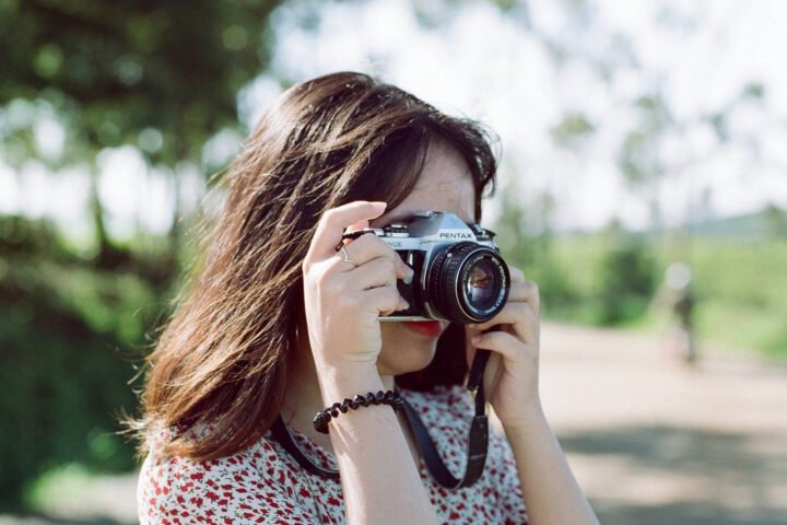 Một người lạ đang chụp ảnh cho một người khác với máy ảnh DSLR