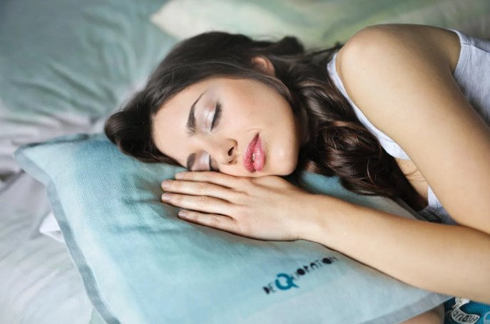 Một người phụ nữ ngồi một mình trên ghế sofa, nhìn xa xăm, thể hiện sự trầm tư về mối quan hệ cũ hoặc những suy nghĩ liên quan đến việc mơ thấy người yêu cũ.