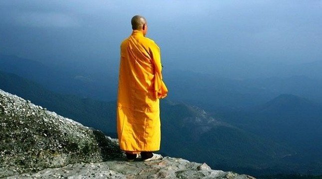 một vị thầy tu đang đi thanh thản trong khuôn viên chùa, biểu tượng cho sự bình yên