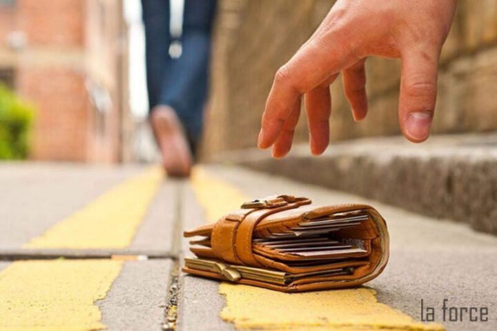 Người đàn ông cúi xuống nhặt chiếc ví tiền rơi trên vỉa hè, ám chỉ giấc mơ thấy lượm tiền đánh số gì.