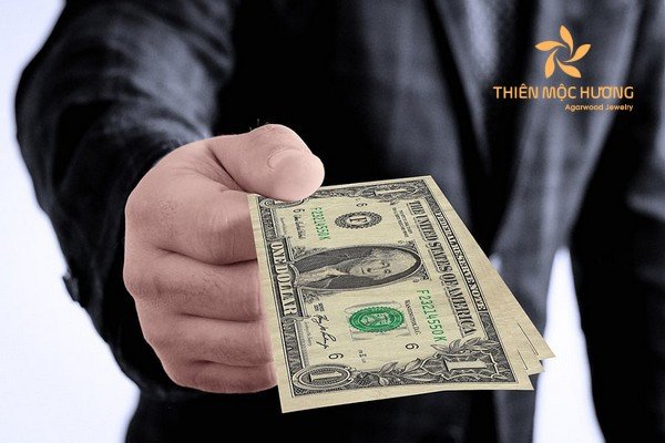 Người đàn ông đưa tiền cho người khác trong bối cảnh mơ