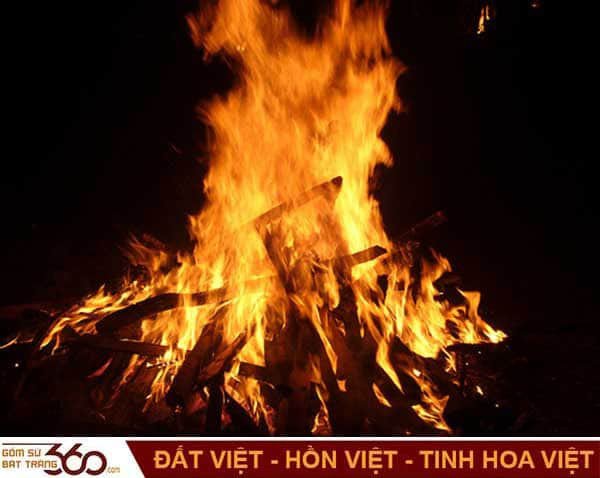 Người phụ nữ đang trầm tư nhìn ngọn lửa, biểu tượng cho những giấc mơ về lửa và điềm báo may mắn