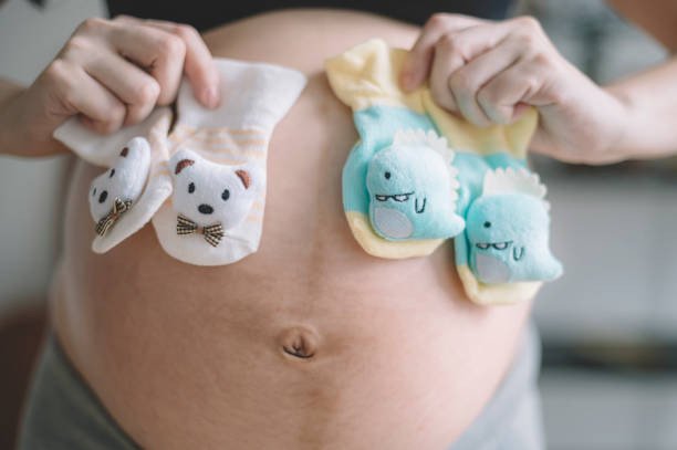 Người phụ nữ hạnh phúc nhìn vào que thử thai, tượng trưng cho niềm vui khi mơ thấy người khác mang bầu.