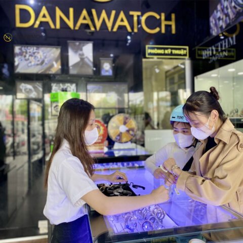Người phụ nữ trẻ đang lựa chọn đồng hồ đeo tay trong cửa hàng