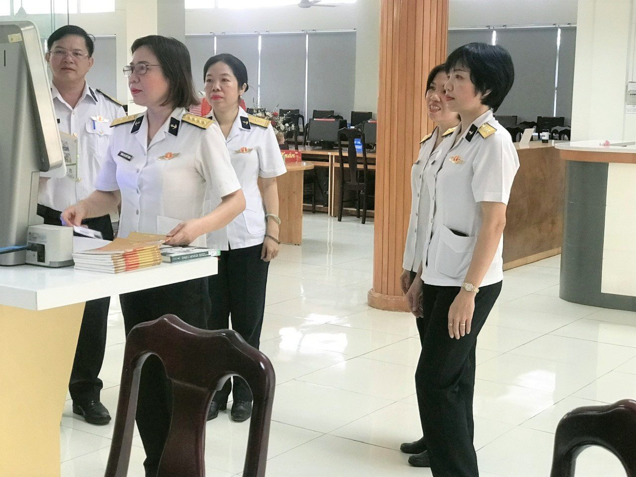 Nhân viên thư viện thao tác máy mượn trả tự động, tối ưu hóa việc quản lý kho tài liệu học tập.