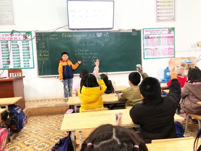 Nhóm học sinh đang làm việc cùng nhau trong lớp học, thể hiện tinh thần hợp tác và hỗ trợ học tập.