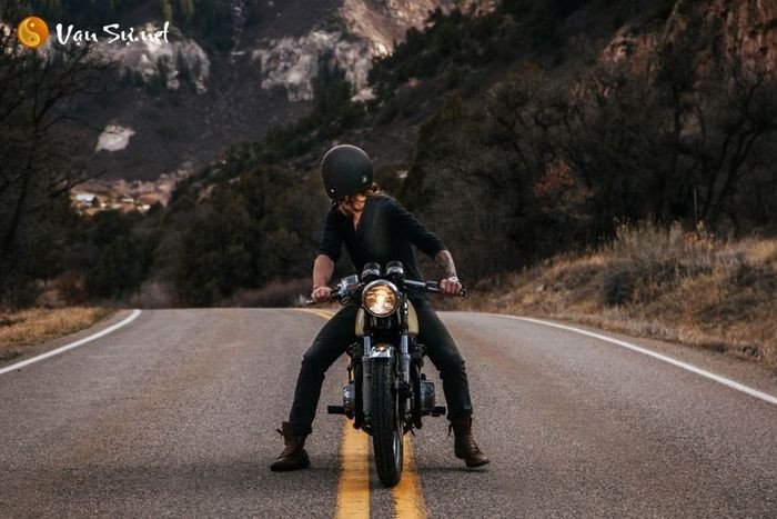 Nữ giới đội mũ bảo hiểm đang ngồi trên xe máy, liên tưởng đến cảm giác kiểm soát khi ngủ mơ thấy xe máy