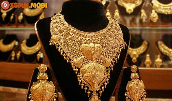 Ý nghĩa chiêm bao thấy nhặt được vàng: Một viên vàng lấp lánh giữa các đồng tiền cổ, biểu thị sự thịnh vượng và những cơ hội vàng sắp đến.