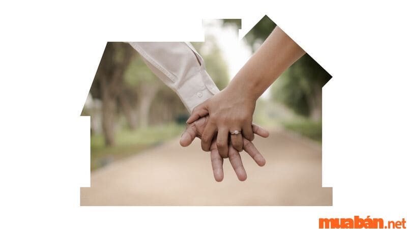 Đôi vợ chồng hạnh phúc đang ngồi trước ngôi nhà đã bán, đếm tiền, biểu tượng cho sự thịnh vượng