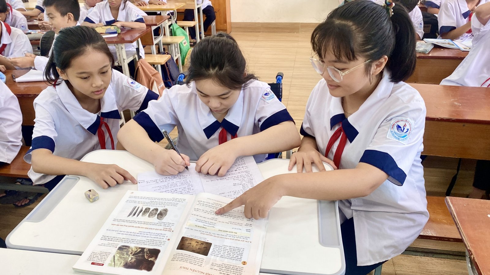 Hai bạn học sinh thân thiết cùng nhau học bài, minh chứng cho việc giúp đỡ bạn bè trong học tập