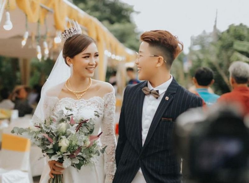 Người phụ nữ đang xem sổ mơ để tìm con số may mắn khi mơ thấy mình mặc váy cưới đánh con gì.