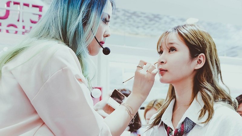 Người phụ nữ trang điểm trước gương phản chiếu bản thân